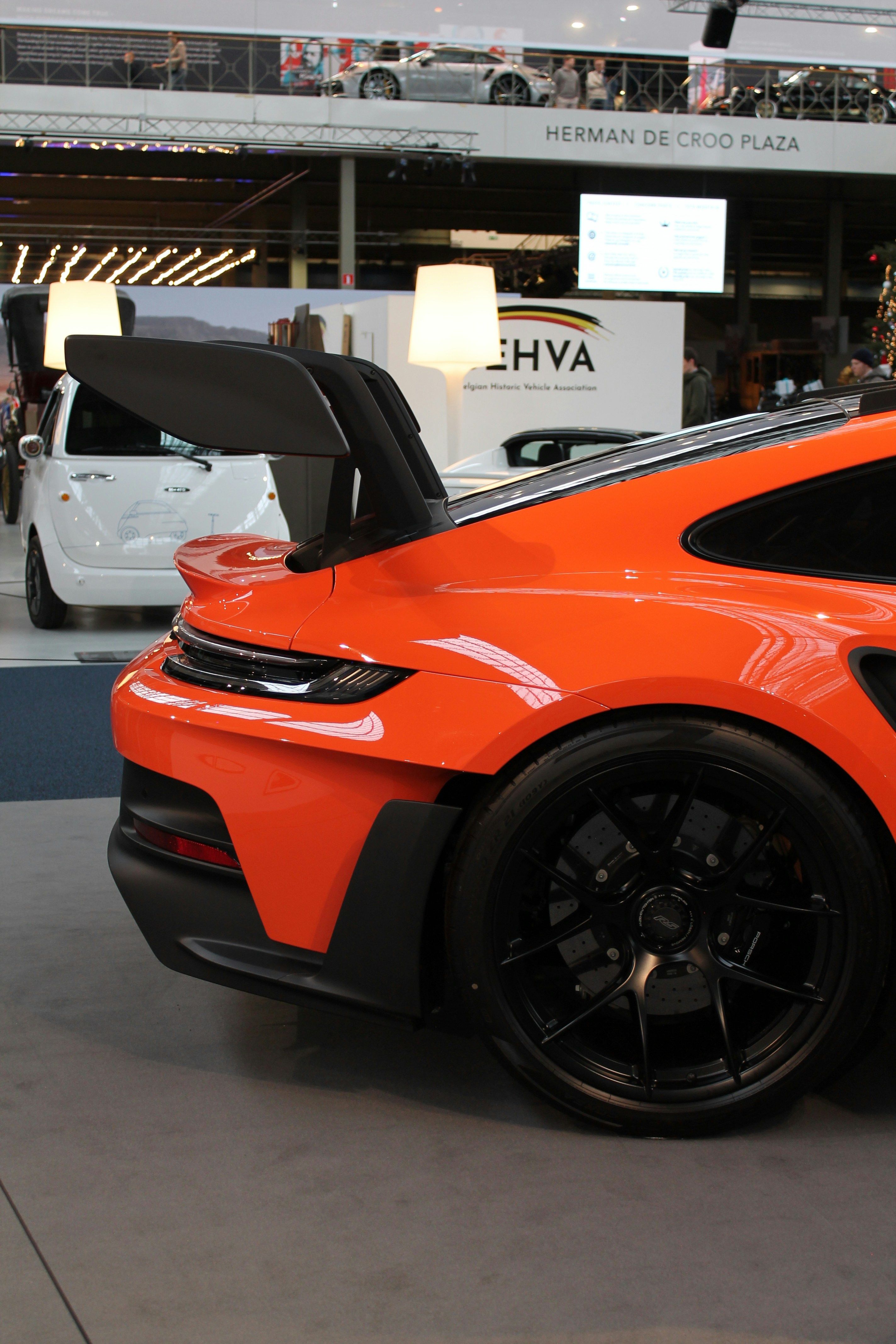 an orange sports car parked in a showroom