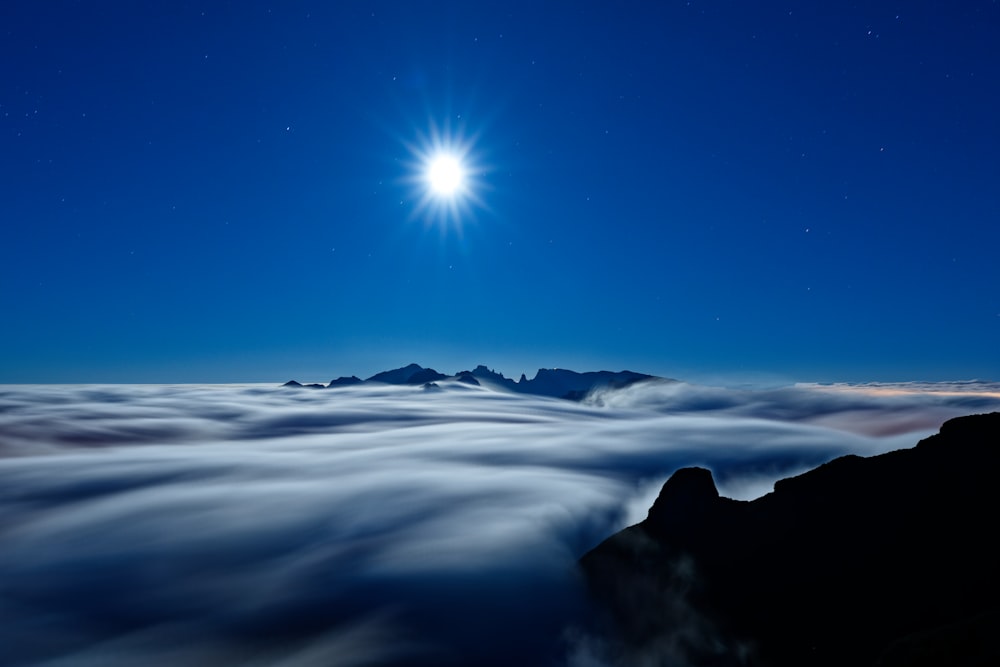 uma lua cheia acima das nuvens no céu