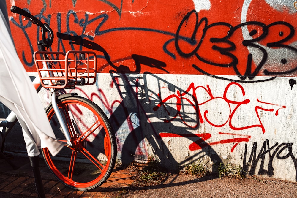 a bike parked next to a wall covered in graffiti