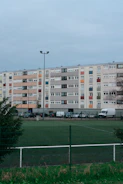 a tennis court in front of a multi - story building