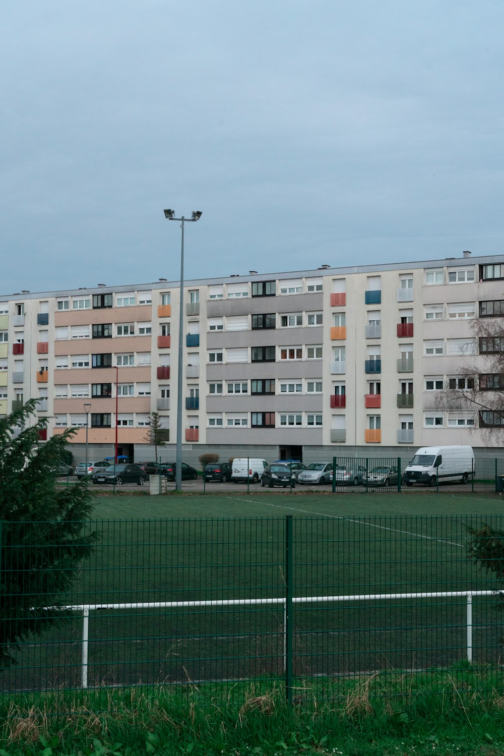 a tennis court in front of a multi - story building