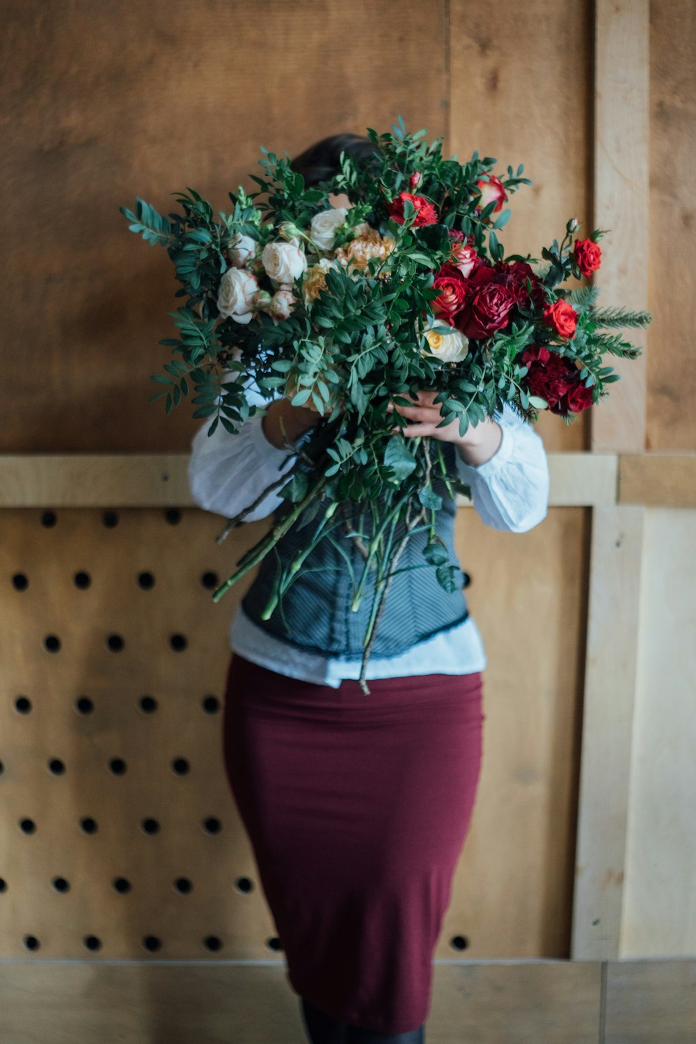 a woman holding a bunch of flowers in her hands