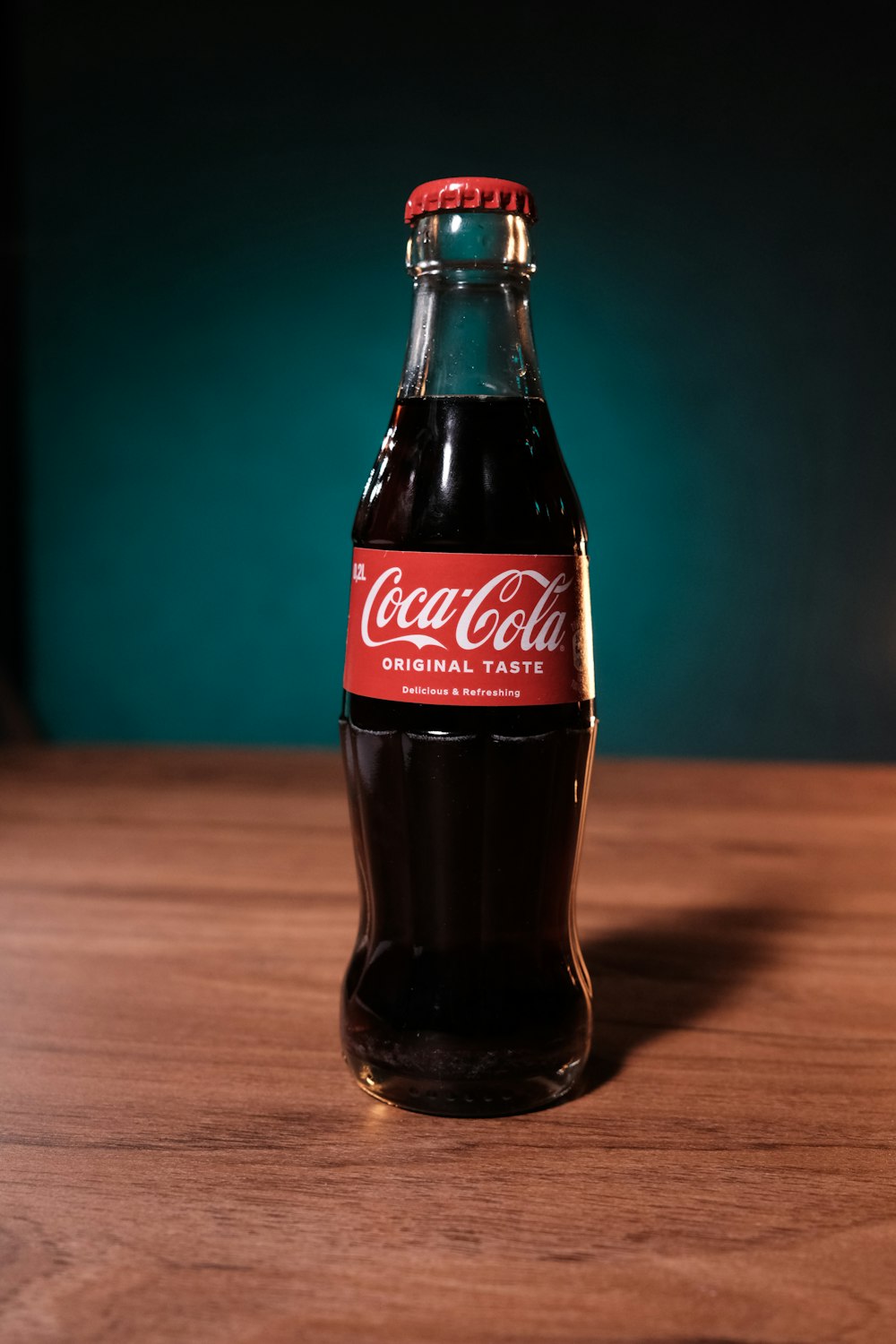 a bottle of coca cola sitting on top of a wooden table