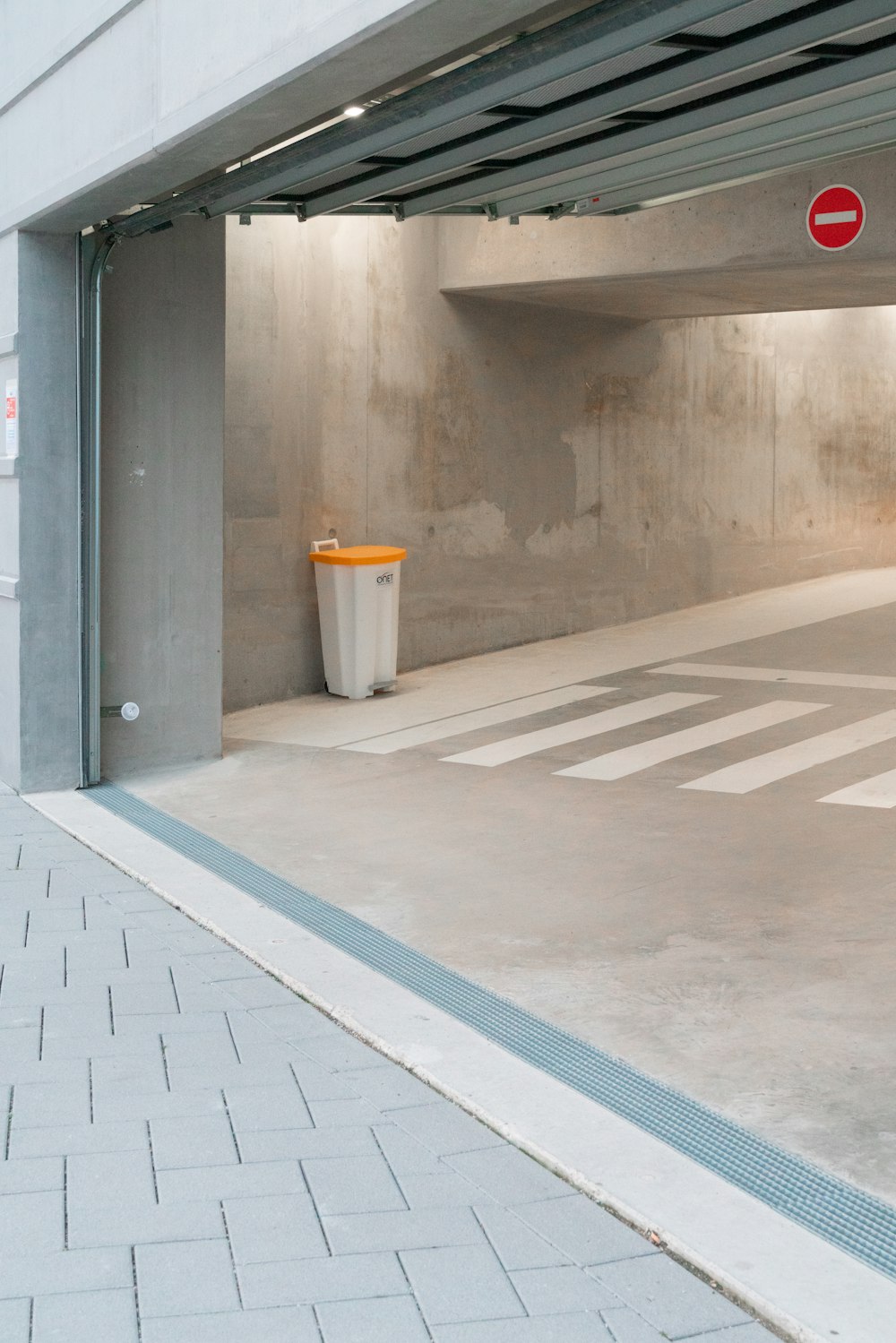 an empty parking garage with a trash can