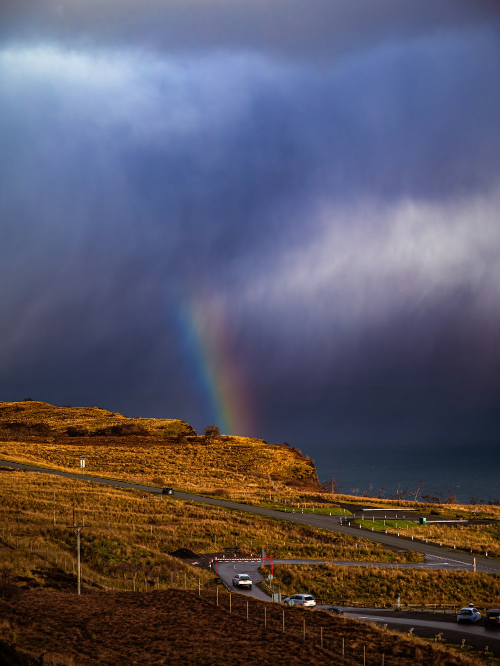 a rainbow in the sky over a road