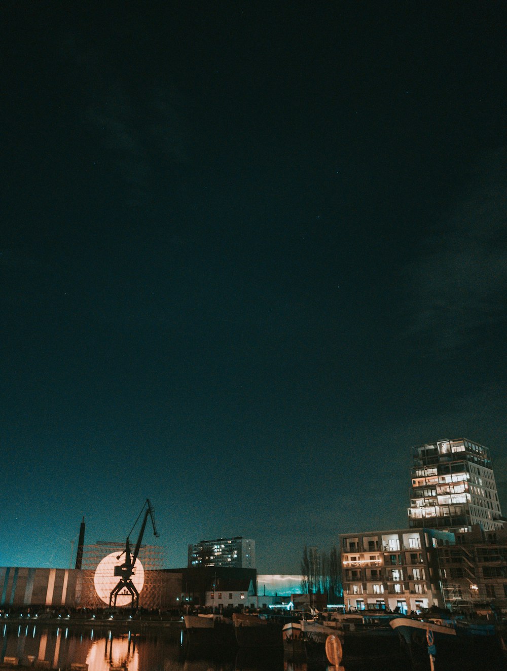 a building with a crane on top of it at night