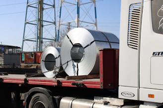 a truck with a large roll of metal on the back of it