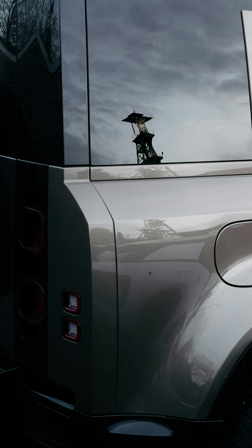 the reflection of a person holding an umbrella in the back of a truck