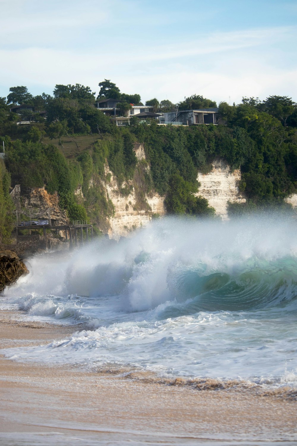 a large wave crashing into the shore of a beach