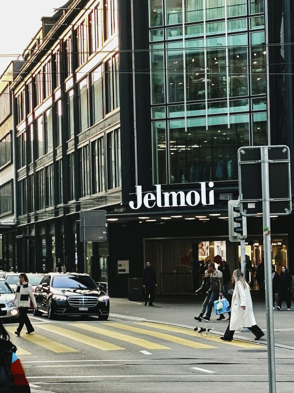 people crossing the street in front of a store