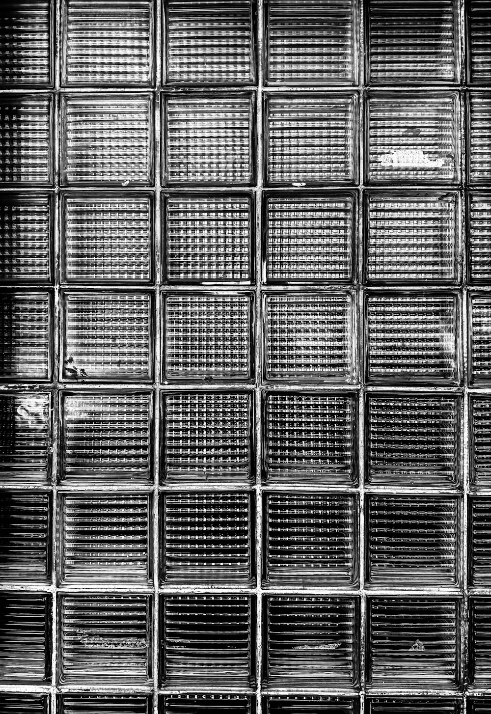 une photo en noir et blanc d’un mur de briques de verre
