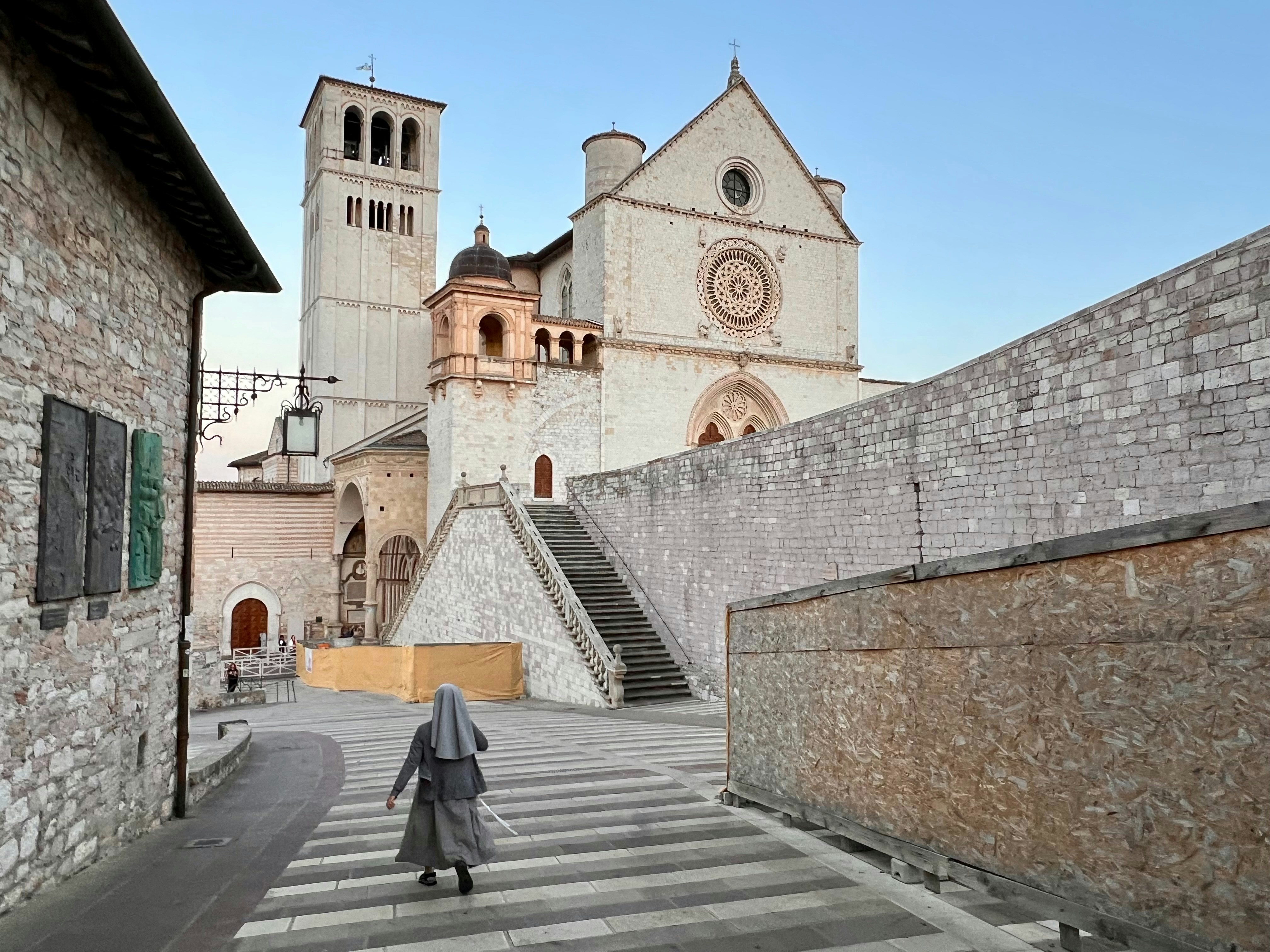 a woman walking down a street in front of a church