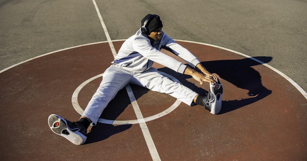 a man sitting on top of a basketball court