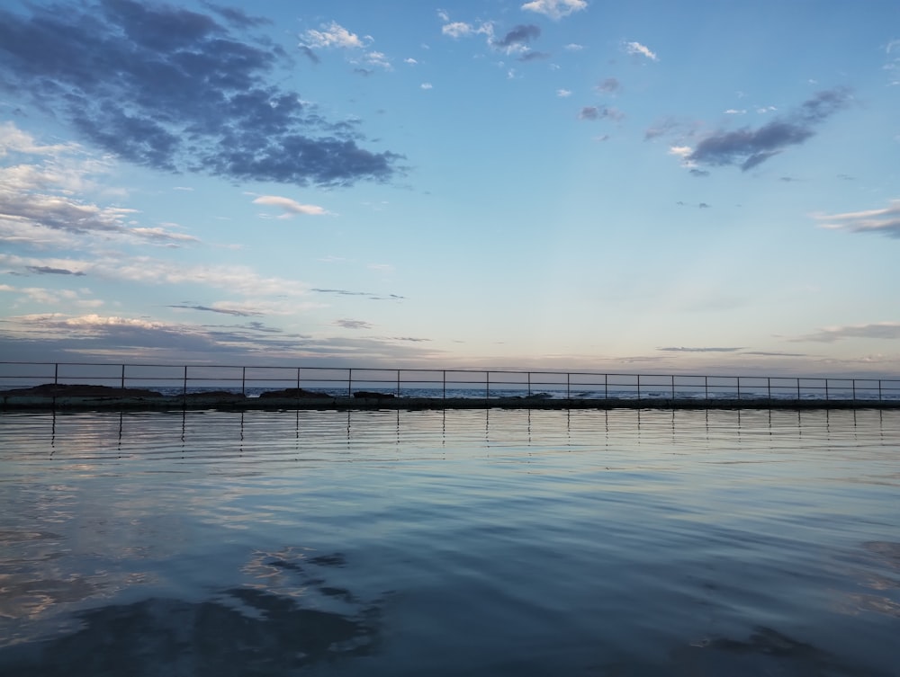 a body of water with a bridge in the background