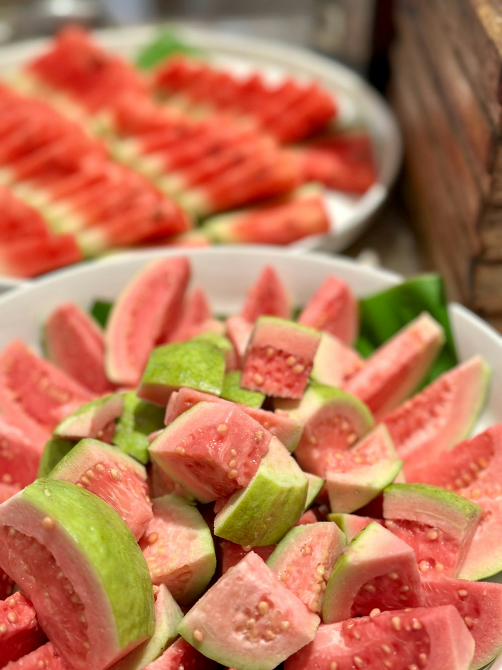 eine weiße Schüssel gefüllt mit in Scheiben geschnittener Wassermelone