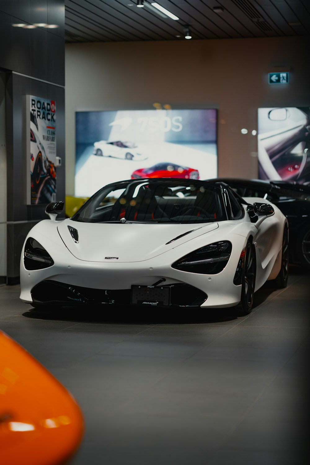 a white sports car is parked in a showroom
