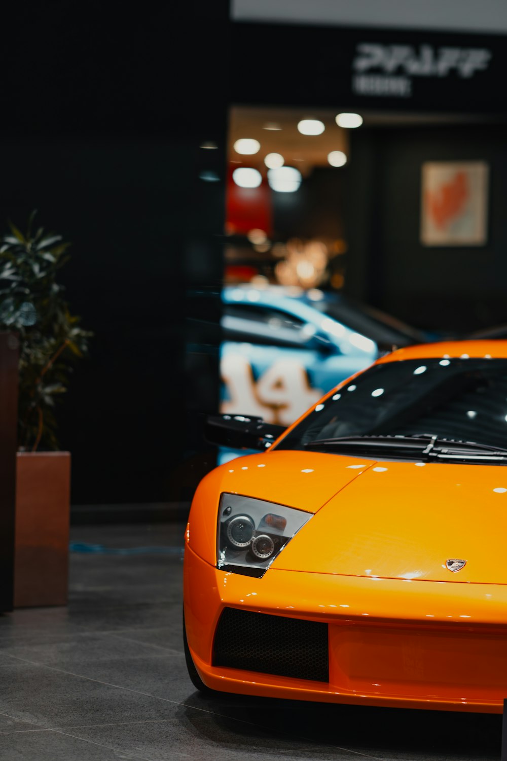 a bright orange sports car is on display