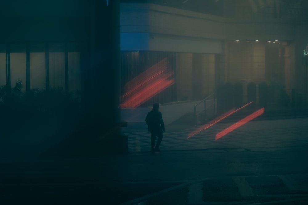 a man walking down a street at night