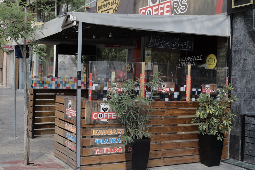 a coffee shop with plants in front of it