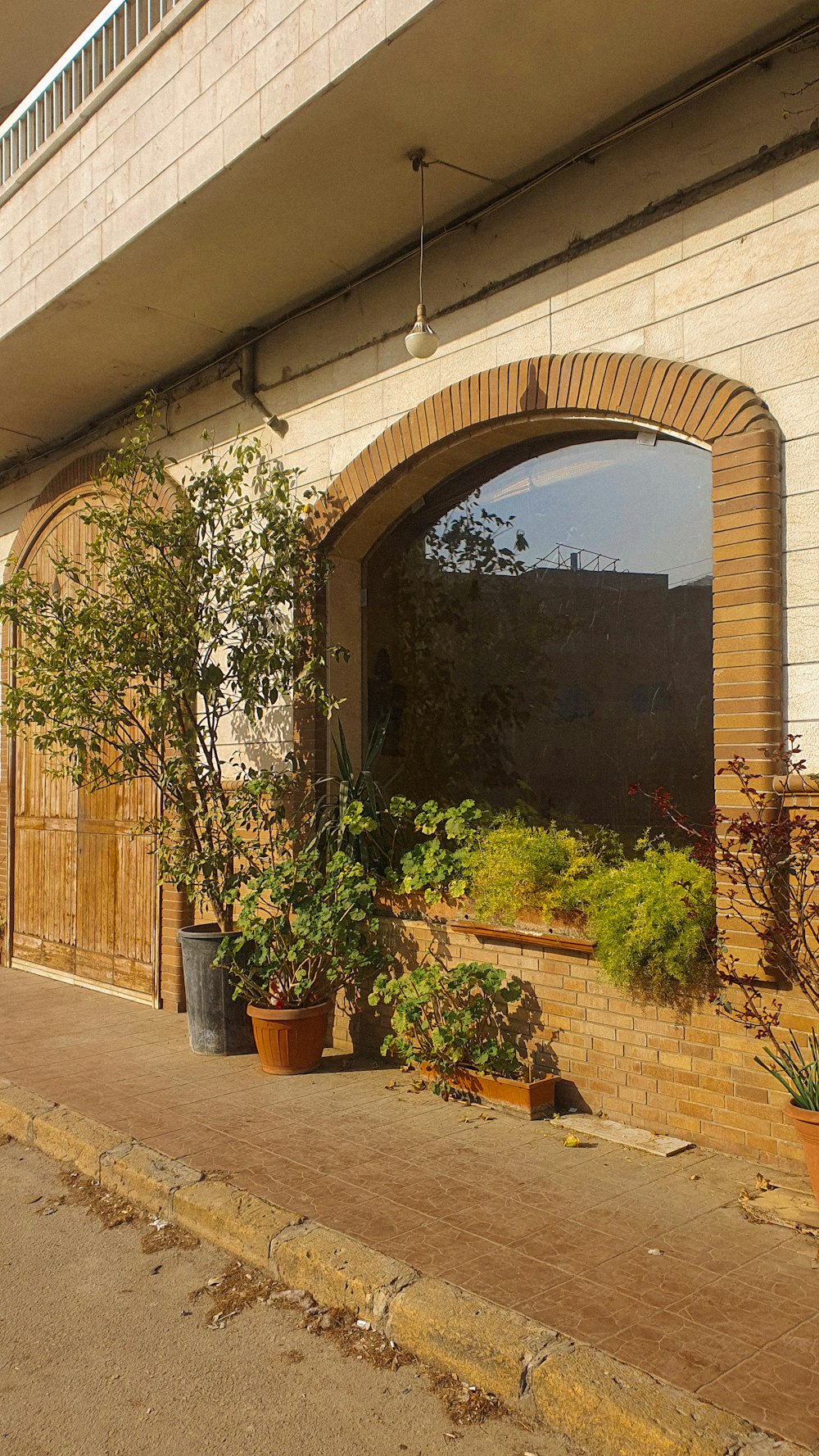 a brick building with potted plants in front of it