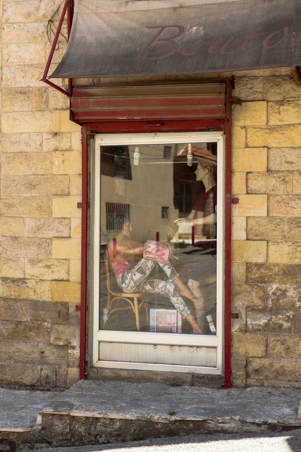 a man sitting in a chair in front of a store window