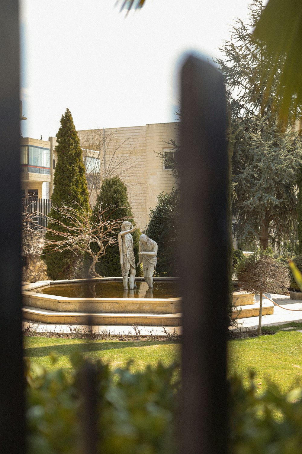 a couple of statues sitting in the middle of a park