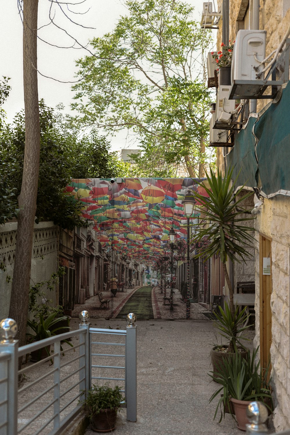 an alley way with a bunch of umbrellas on it