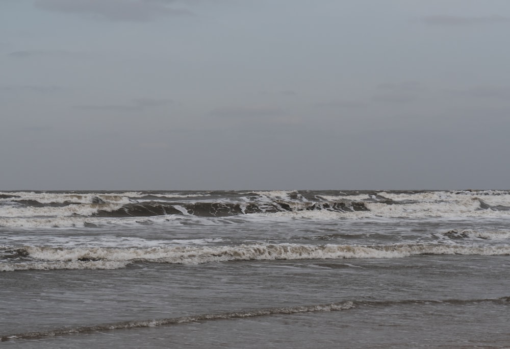 a person standing in the ocean with a surfboard