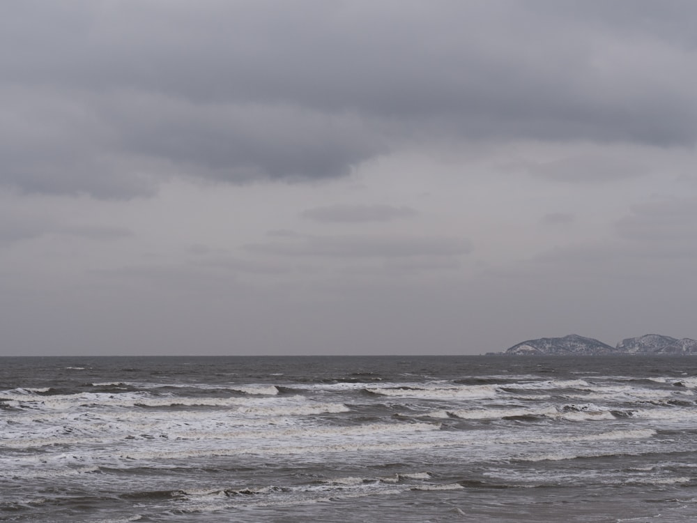 a large body of water with a mountain in the distance