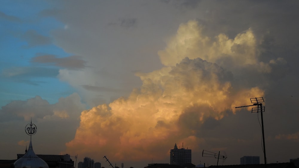 a large cloud looms in the sky over a city