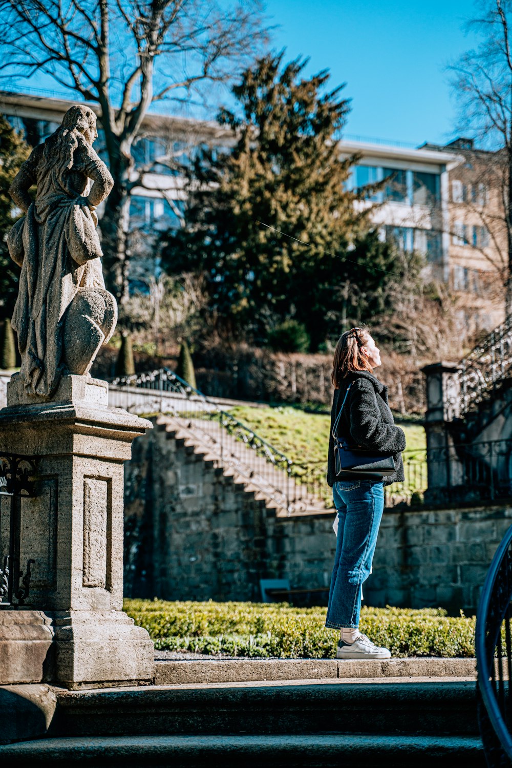 a woman standing in front of a statue