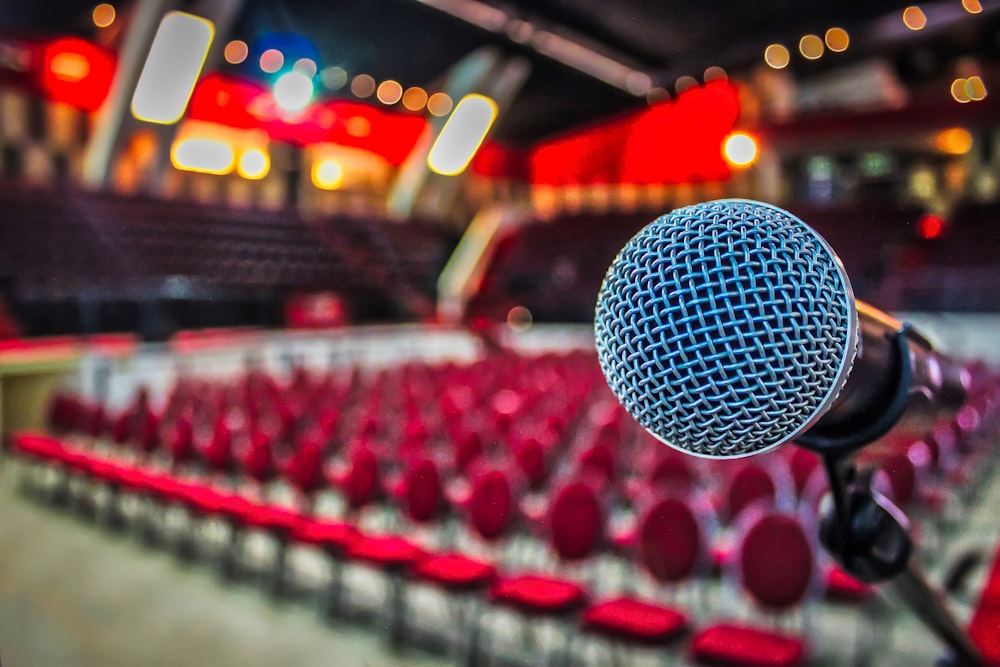 a microphone in front of a row of red chairs