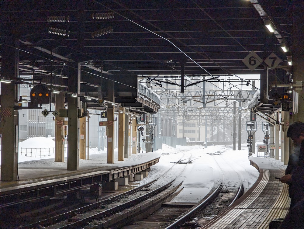 a train station with tracks covered in snow