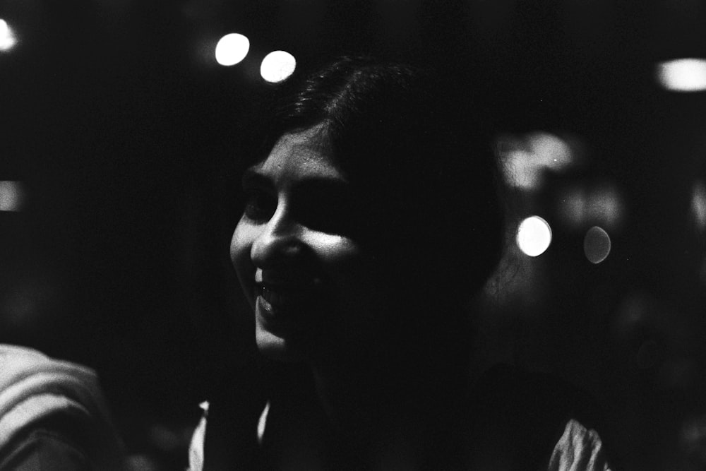 a black and white photo of a woman in the dark