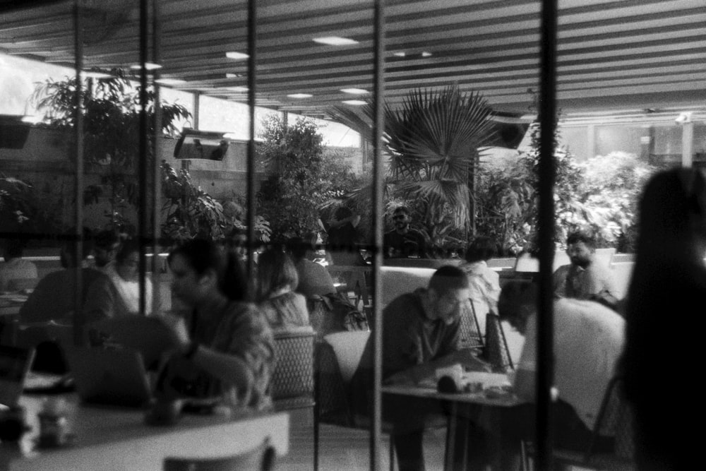 a group of people sitting at tables in a restaurant