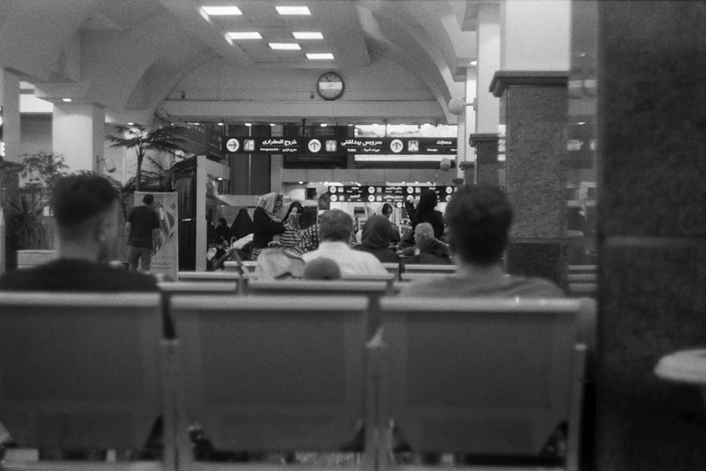 a black and white photo of people sitting in chairs