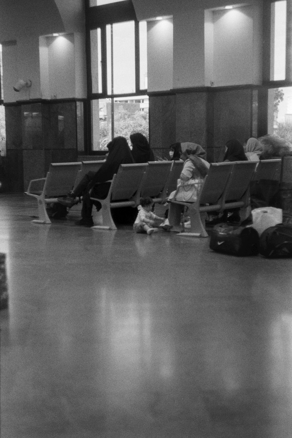 a black and white photo of people waiting in an airport