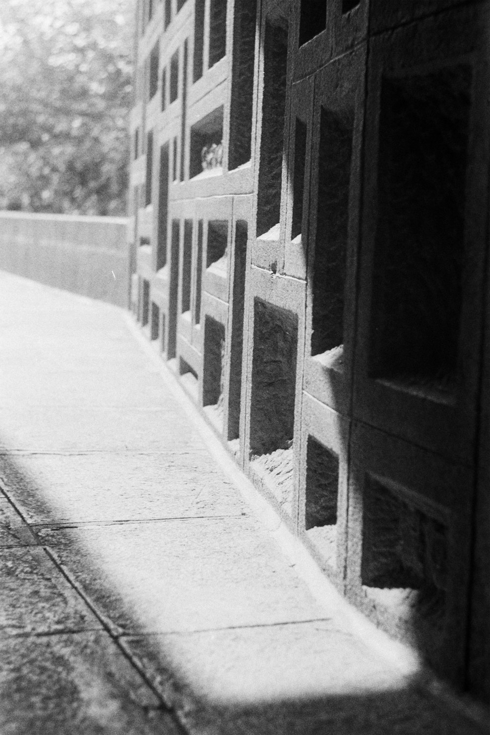 a black and white photo of a sidewalk and a building