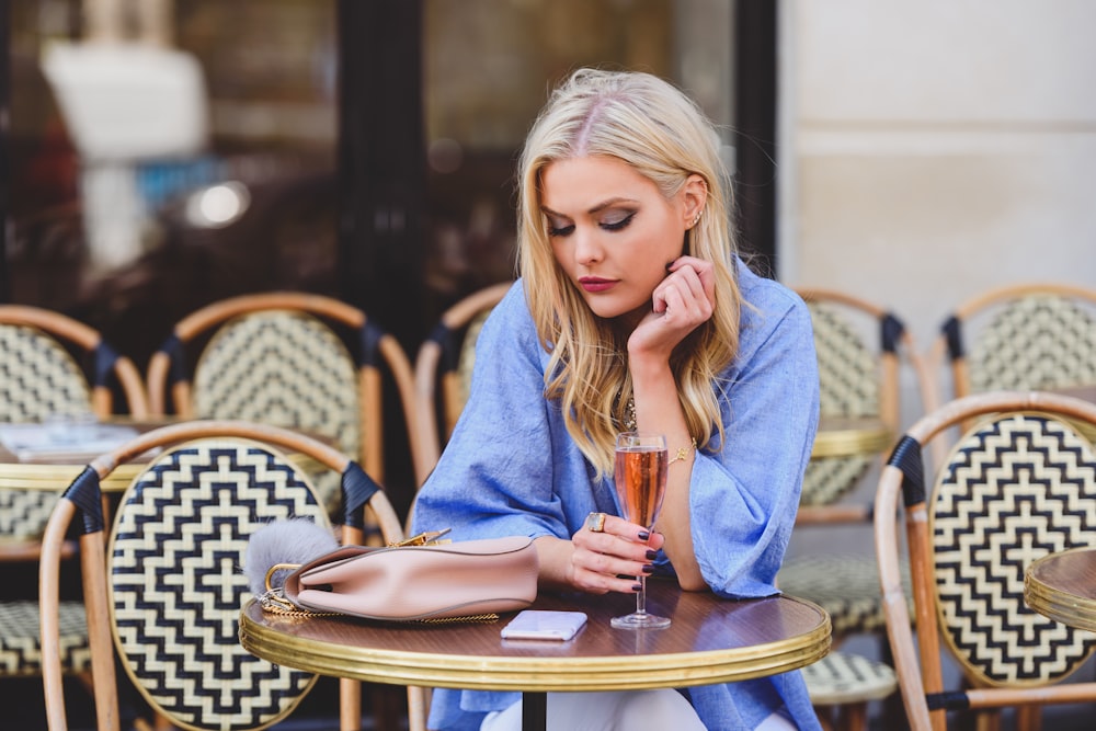 a woman sitting at a table with a glass of wine