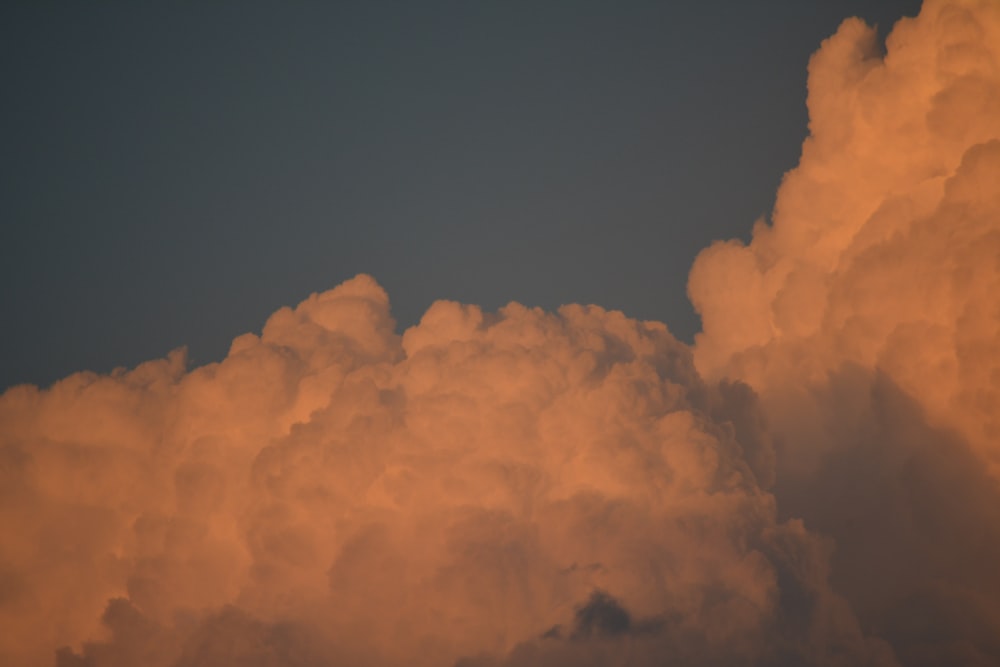 a plane flying through a cloud filled sky