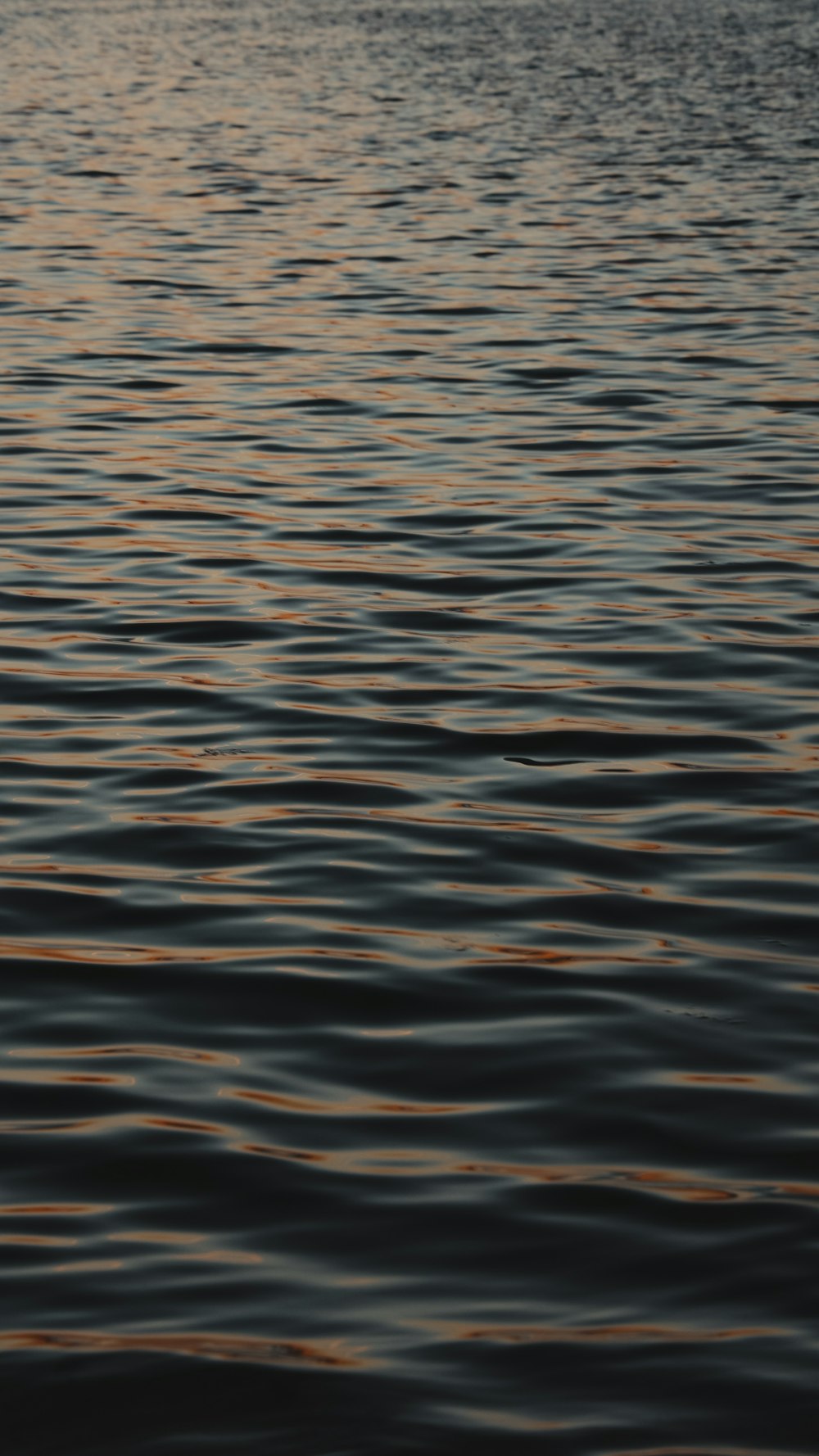 a large body of water with a boat in the distance