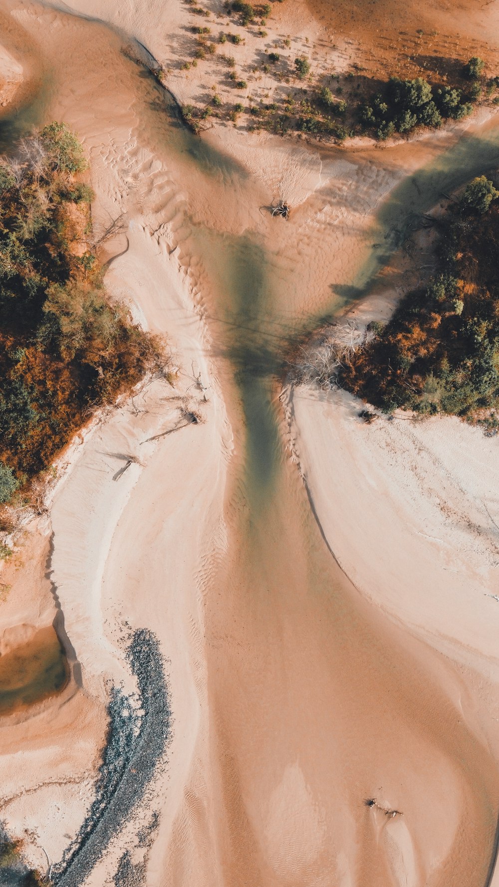 an aerial view of a river running through a sandy area