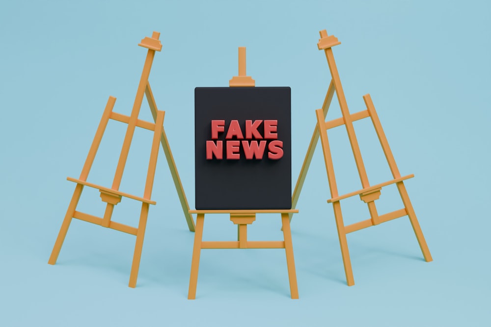 a fake news sign sitting on top of a easel