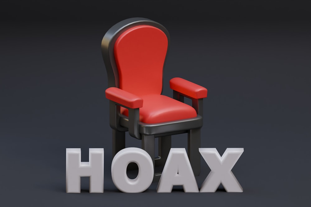 a red chair sitting next to the word hoax