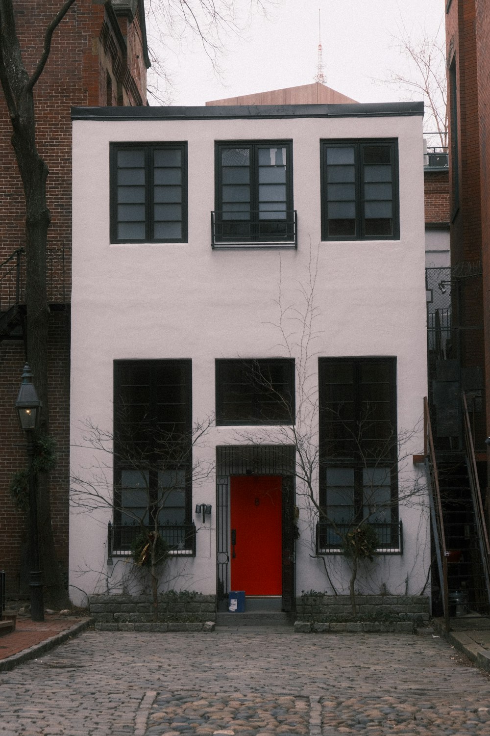 a white building with a red door and windows