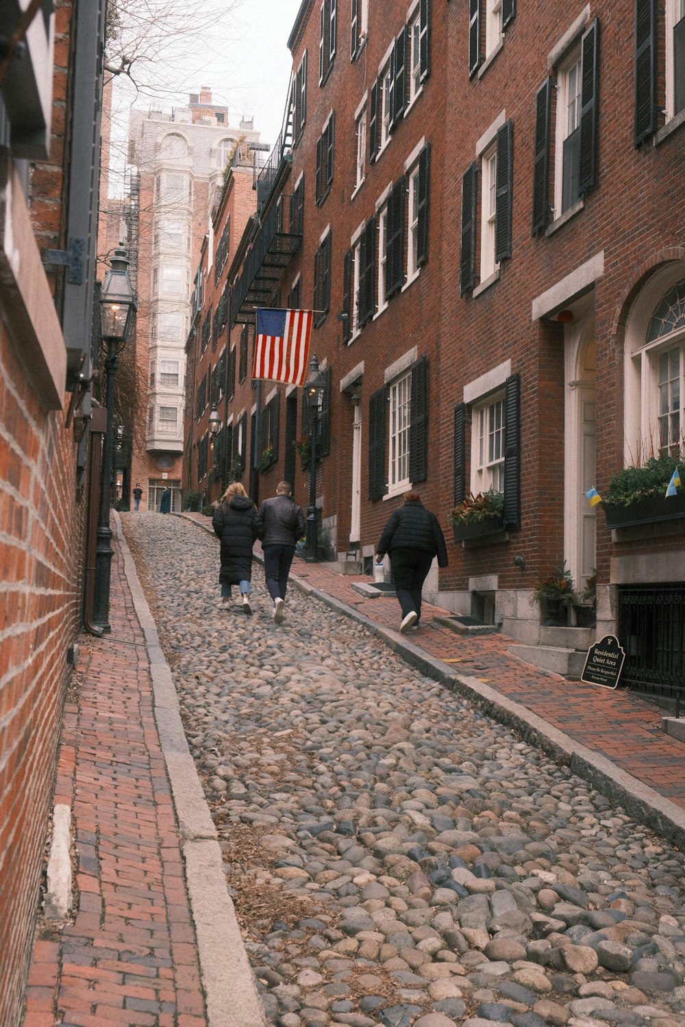 a group of people walking down a cobblestone street