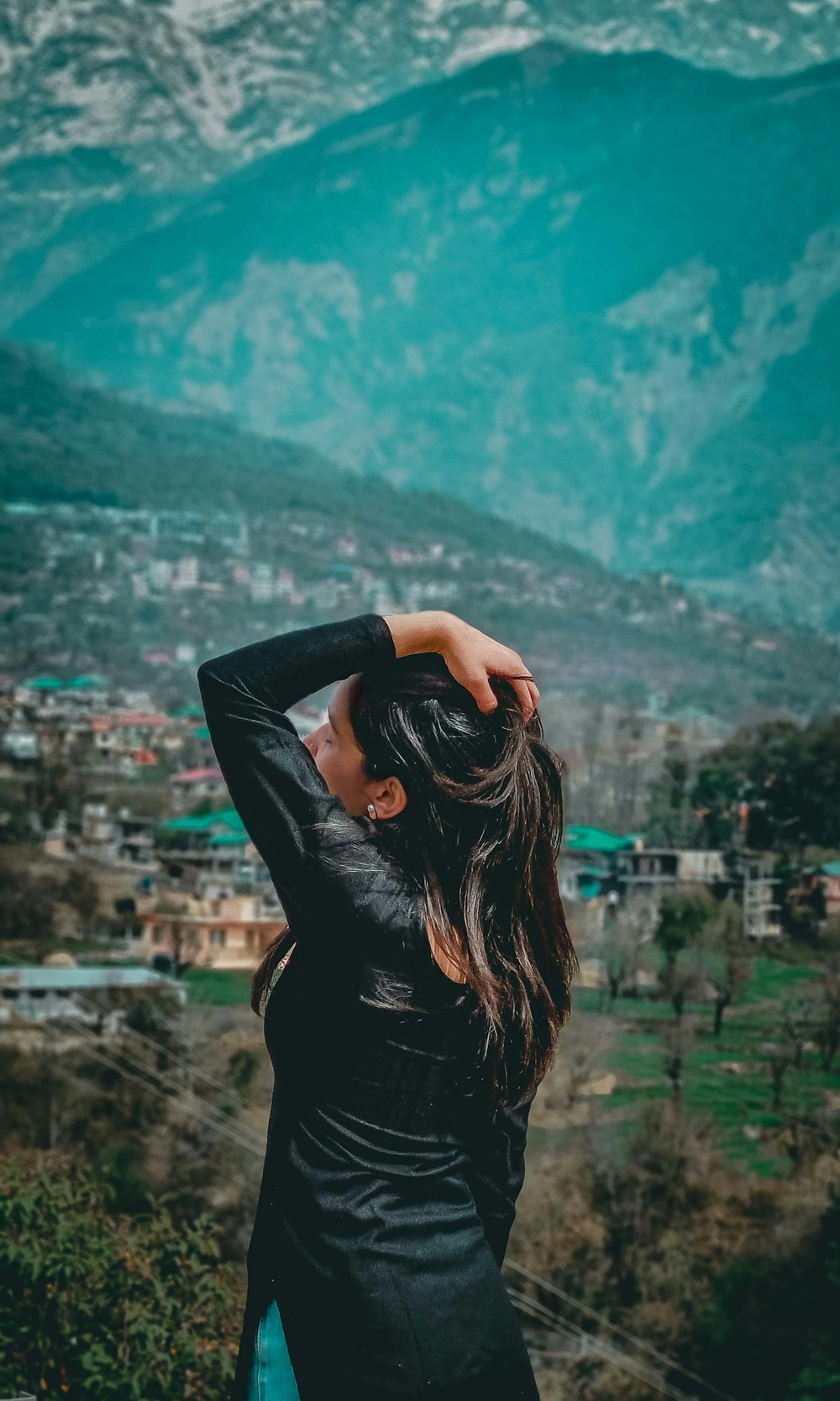 a woman standing on top of a lush green hillside