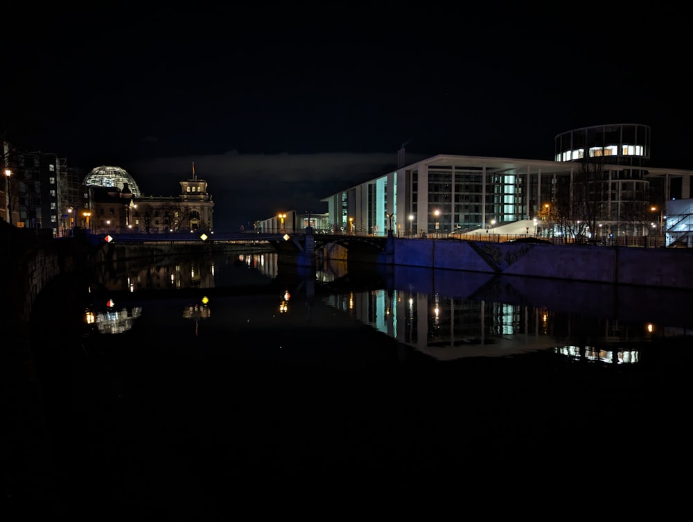 a city at night with a bridge and buildings