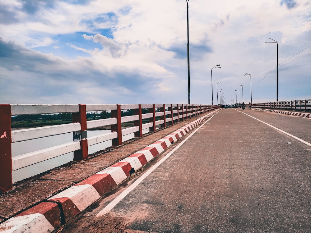 an empty road with a red and white barrier on the side