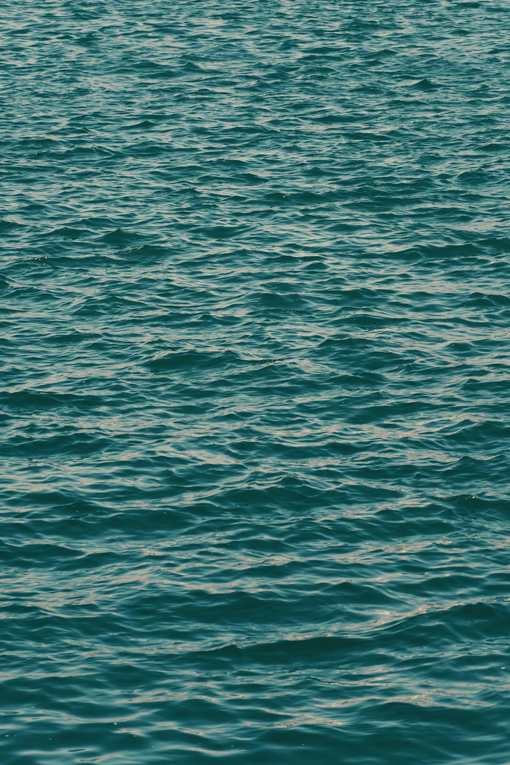 a large body of water with a boat in the distance